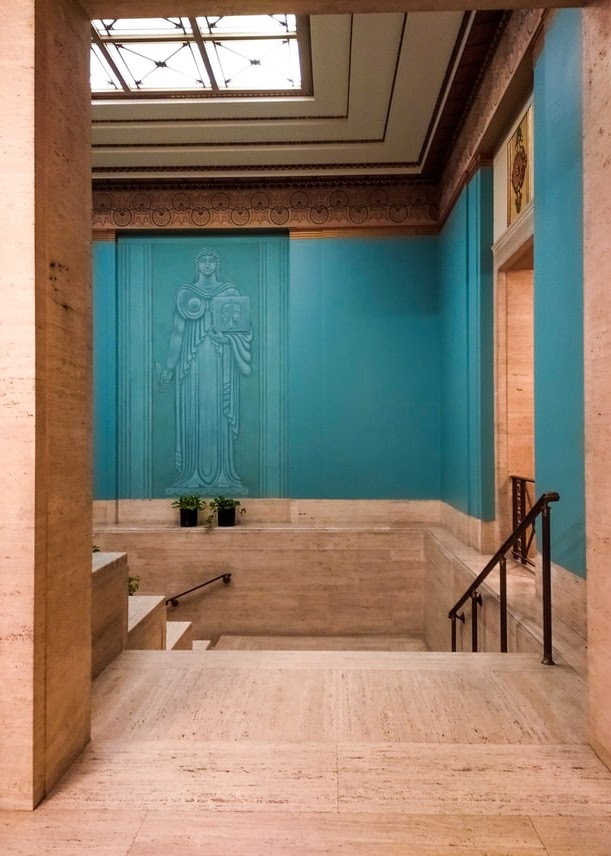 hallway with stairs in a courthouse with teal walls and wood colored floor